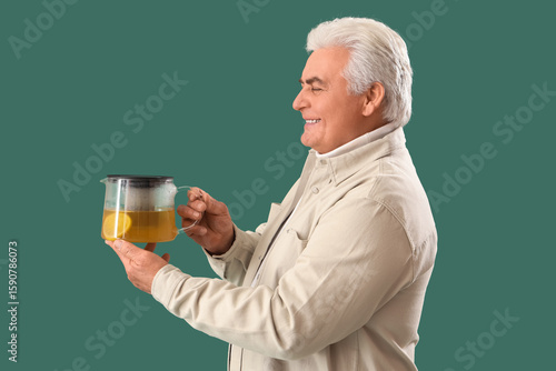 Mature man with teapot on g...