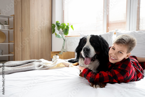 Little boy hugging Bernese ...