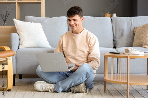 Young man using laptop on f...