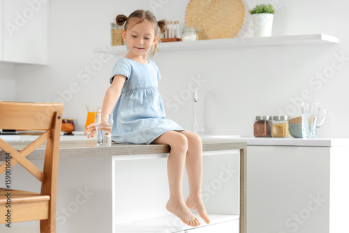 Cute little girl with glass...