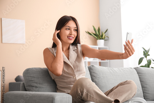 Young Asian woman with mobi...
