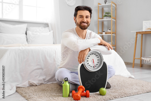 Young man with weight scale...