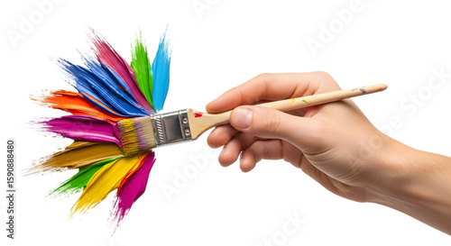 Hand holding paintbrush loaded with vibrant multicolored paint streaks.