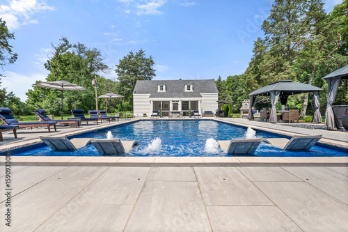 Fotografi Luxury pool house with water fountain feature and stunning setup under clear blu