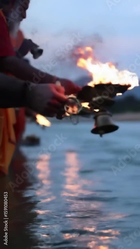 Devotees performing Ganga Aarti on the riverbank at dusk, flames reflecting on water, bells ringing, sacred energy, high detail
