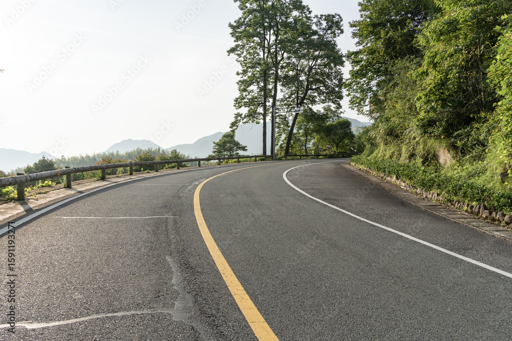 Fototapeta premium empty asphalt through mountain as background