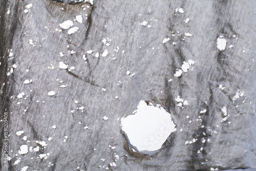 Holes in old dirty ragged shirt, grunge ripped texture cloth, Torn gray white fabric with many holes