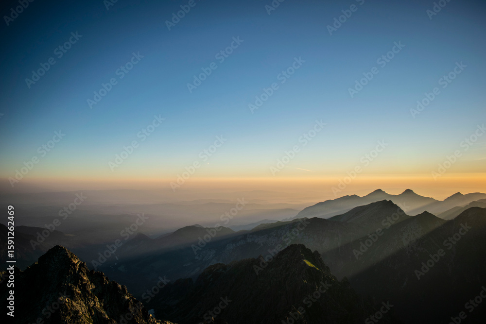 Naklejka premium Mountain peaks at sunrise. Sunlight falling, painting with light, Rysy in the Polish Tatra Mountains