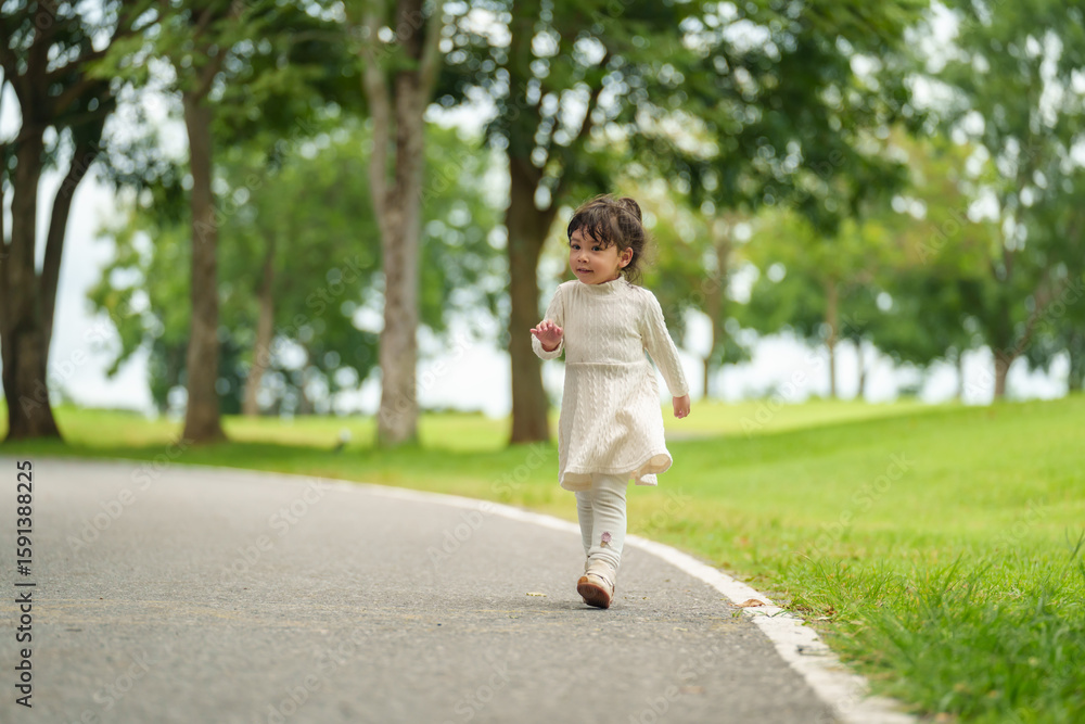 happy toddler girl walk along a pathway in park happy toddler girl walk along a pathway in park