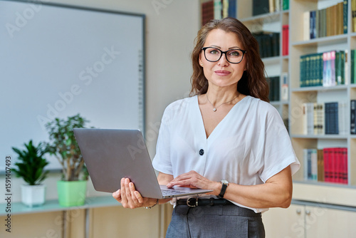 Quadro su tela Portrait mature woman teacher, educational behavioral specialist with laptop in