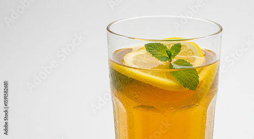 A refreshing glass of lemon tea served in a clear glass with ice cubes and fresh lemon slices. This beverage radiates natural freshness, perfect for a hot day. Placed on a wooden table with soft natur