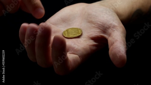 Financial savings and money concept.
Mathelic coin and cent in hands on a black background close-up.
Penny in a man's hand.
A man holds a cent in his hands.
Cents and coins