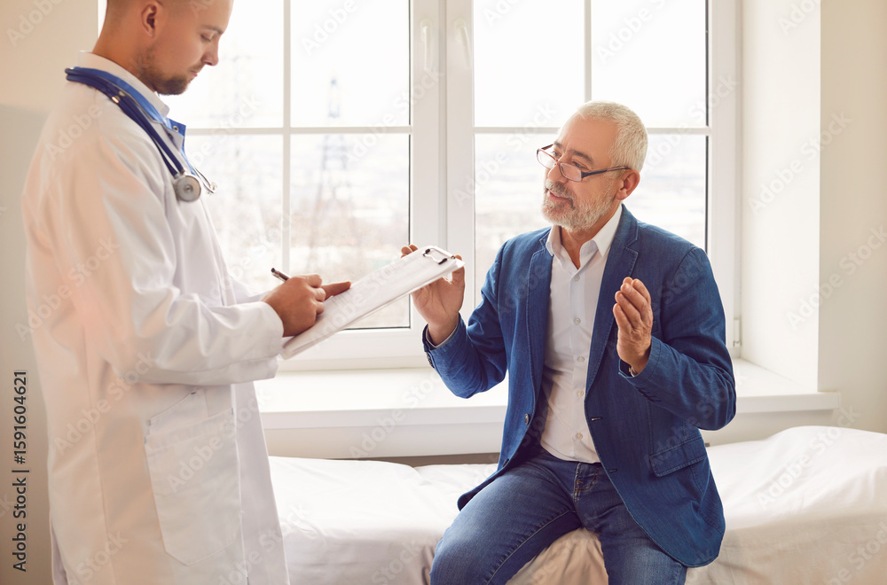 Obraz premium Senior male patient is having a consultation with a doctor or nurse during a visit to the hospital office. Care and treatment provided to elderly people, medical consultation and healthcare support.