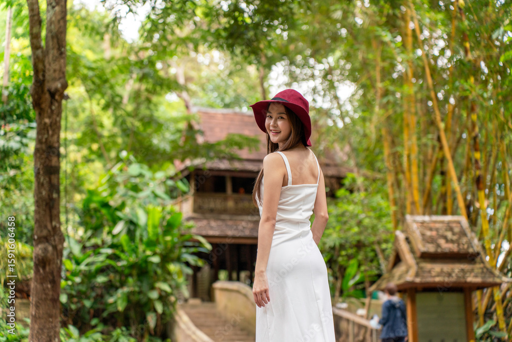 Obraz premium Asian woman exploring Wat Pha Lat temple in Chiang Mai. Young tourist enjoying serene travel moments at historic jungle temple in Northern Thailand.