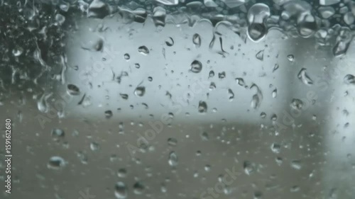 Close-up of raindrops on glass window during winter season  