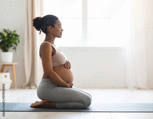 Peaceful young Black pregnant woman practicing prenatal yoga and meditation on mat indoors
