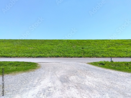 Wallpaper Mural 初夏の江戸川河川敷の駐車場に入る砂利道と若草生える土手風景 Torontodigital.ca