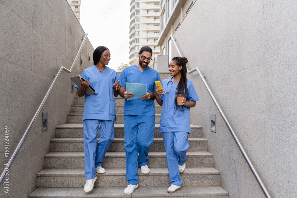 Obraz premium Multiracial medical students walking down hospital stairs
