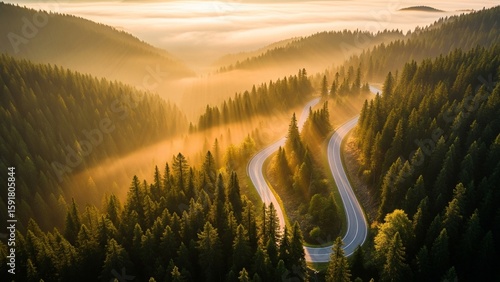Aerial View of Winding Mountain Road at Sunrise with Golden Mist for Travel and Adventure Concepts