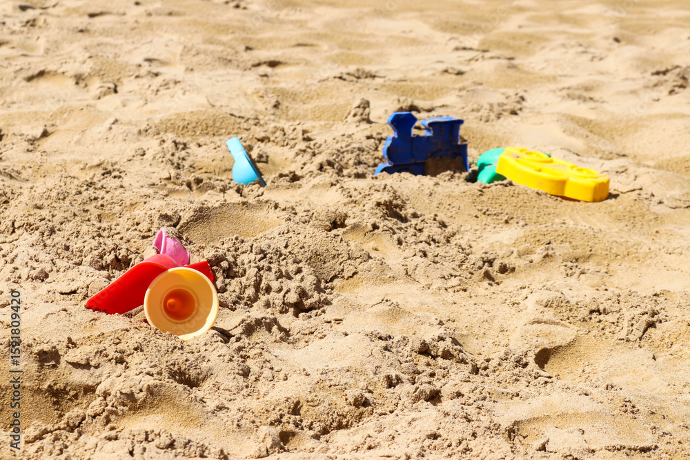Children's beach toys scattered in sand Children's beach toys scattered in sand