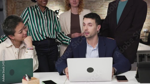 Business team analyzing data on laptop in office