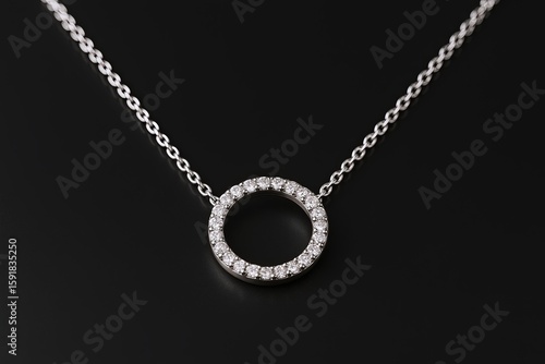 Elegant silver circle pendant necklace adorned with sparkling gemstones on fine chain.