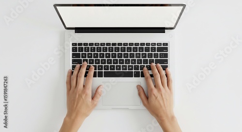 Overhead view of hands typing on a modern laptop with a blank white screen