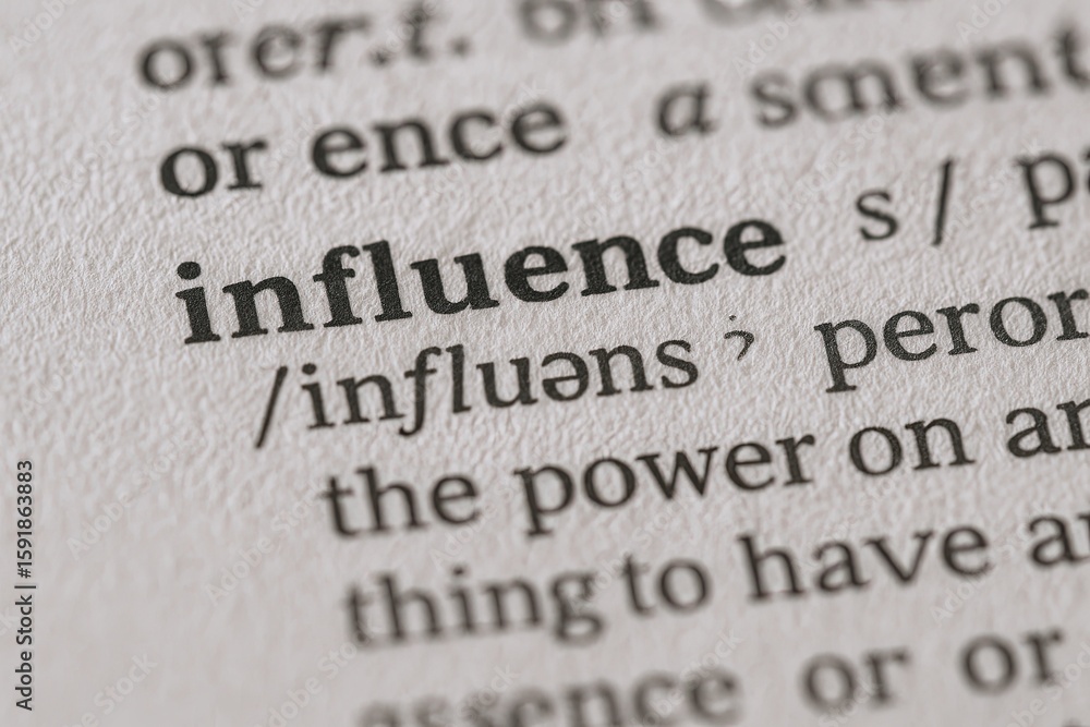 Obraz premium Close-up of a dictionary page showing the word influence with pronunciation and definition.