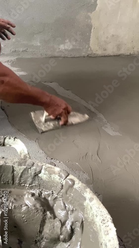 Construction Worker Spreading Wet Cement on Floor