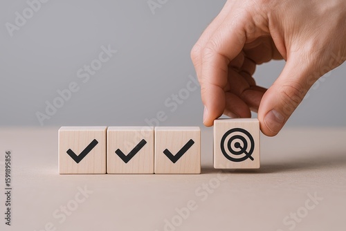 Hand placing wooden block with target icon on row of blocks with check marks.
