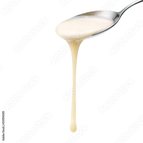A close up of a spoon holding and dripping a creamy white liquid substance down on transparent background