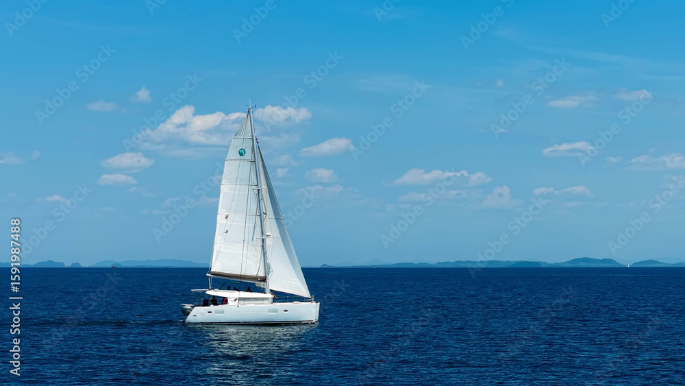 Obraz premium Yachting in the tropics. White sailing catamaran with raised sails moving on the sea. Sailing yacht in the ocean.