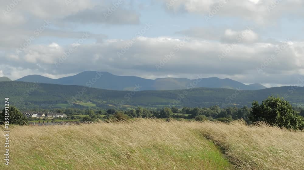 Majestic mountains rise above rolling fields under a brilliant sky in a serene landscape at a quiet moment of dawn Majestic mountains rise above rolling fields under a brilliant sky in a serene landscape at a quiet moment of dawn