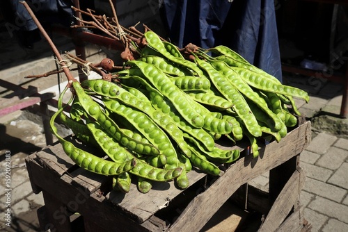 Принти на полотні Petai or stinky beans placed on a wooden box and being sun-dried at a traditional market