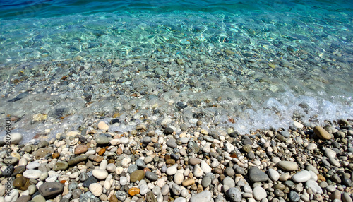 Clear Turquoise Water Washing Over Smooth Pebbles on a Beach