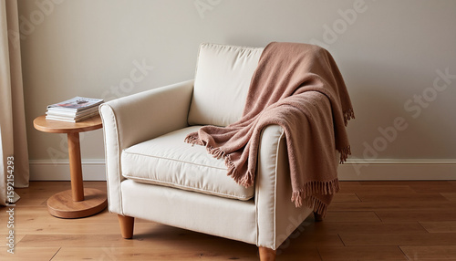 Cozy armchair with pink blanket and wooden side table in modern room  