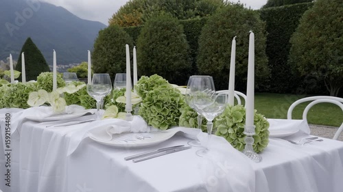 An Elegant Outdoor Dining Setup Featuring Beautiful Greenery and Soft Candlelight. Action