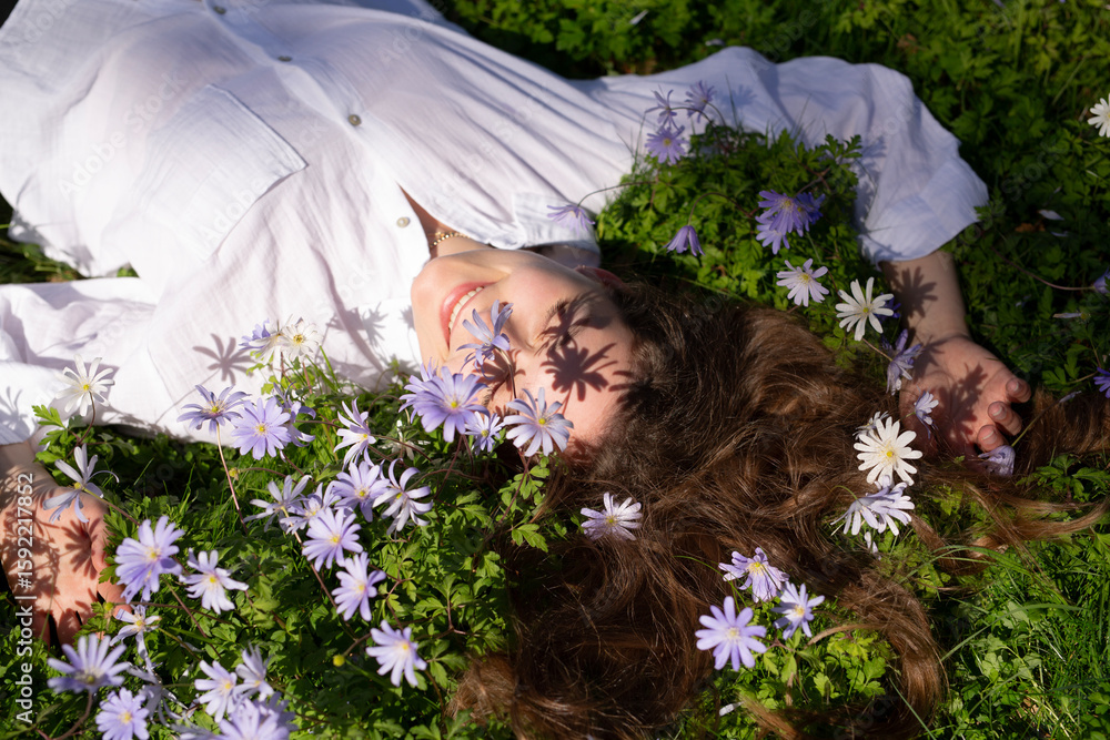 Naklejka premium A Woman Lying Peacefully in a Field of Flowers Experiencing a Tranquil Moment in Nature