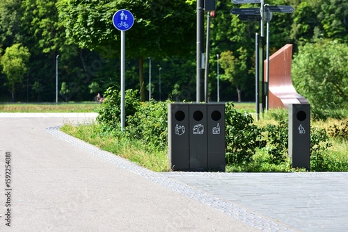 Obraz na plátně Modern waste sorting bins along city sidewalk near park