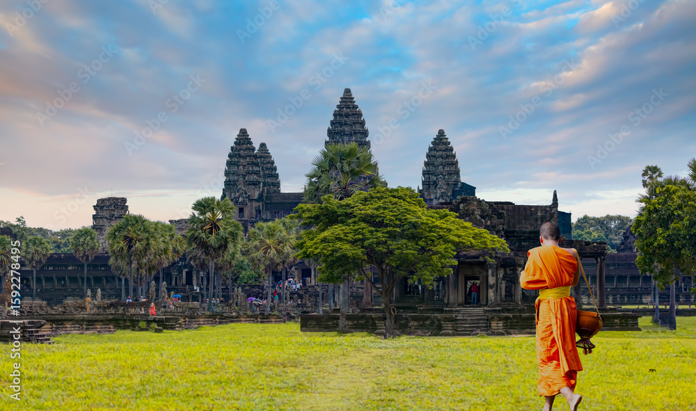 Obraz premium Asian monk waling on the green grass and look to Angkor wat in Siem Reap, Cambodia