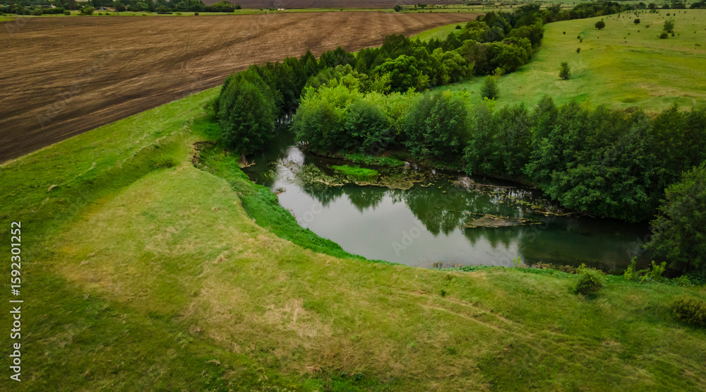 aerial landscape of a river and a green field aerial landscape of a river and a green field
