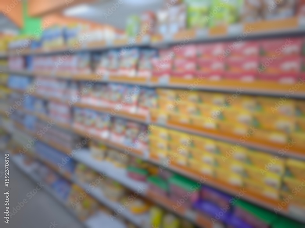 Fototapeta premium Blurry image of a supermarket aisle with shelves full of products. An abstract retail background for business, shopping, supermarket concepts, or consumer markets.