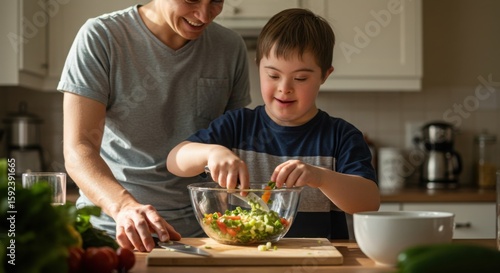 Man assisting boy with Down syndrome while preparing salad in kitchen  