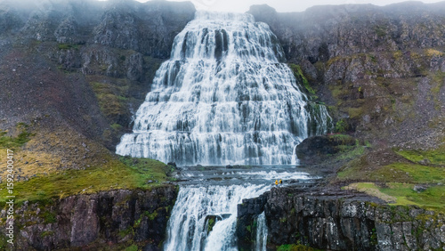 Fototapeta Naklejka Na Ścianę i Meble -  Experience the beauty of a stunning waterfall pouring from rugged cliffs in Iceland, surrounded by lush greenery and dramatic rock formations. Dynjandi waterfall, Westfjord, Iceland