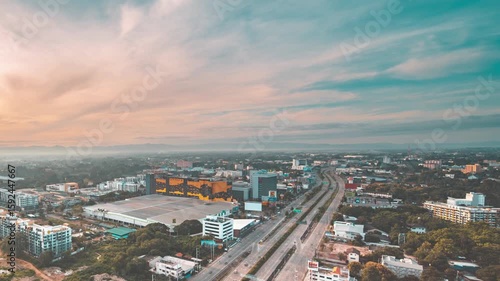 An aerial view of a city skyline at sunset with a highway
