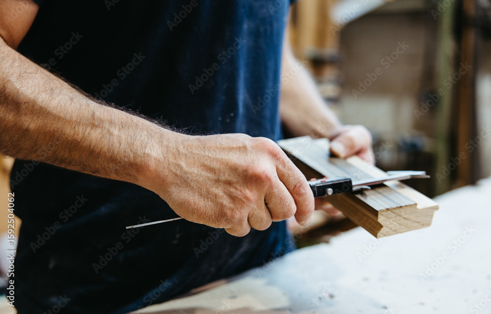 Obraz premium Close-up of hands measuring wooden piece with caliper in workshop
