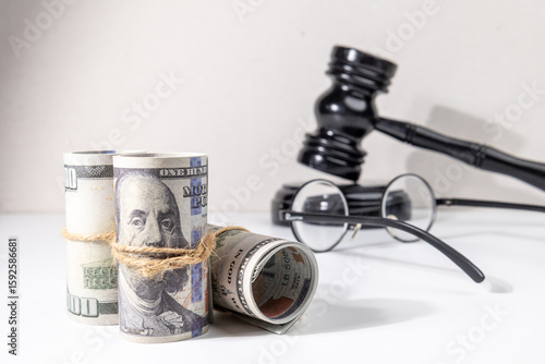A gavel set behind bundles of money conveys the concept of financial consequences, court verdicts, or legal disputes involving monetary resolutions.

