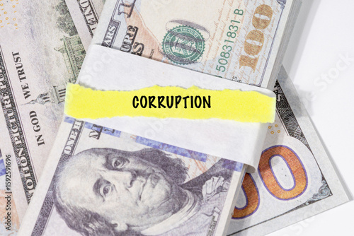 A note marked “Corruption” is set on a spread of cash, highlighting misuse of public funds and unethical financial practices.