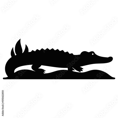 Silhouette of a crocodile resting on a riverbank