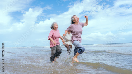 Three women enjoy a joyful walk along the beach during a sunny afternoon with gentle waves and clear blue skies
